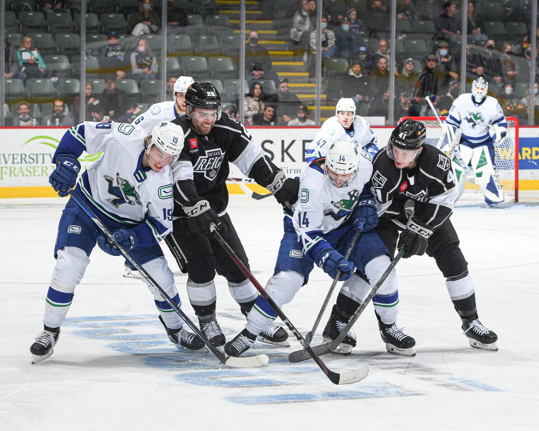 Canucks players and Reign players battling for possession.