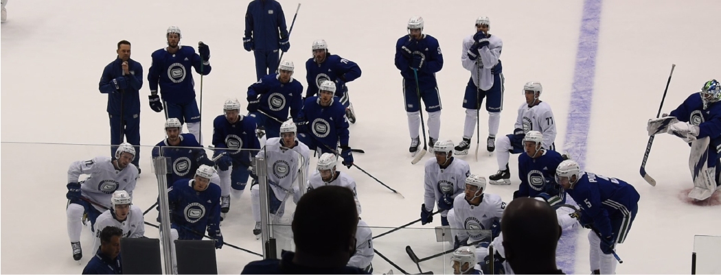 The Abbotsford Canucks circle up on the ice during training camp.